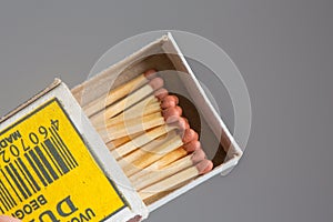 Box of matches on gray background.Matches in the hand.