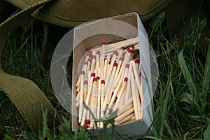 Box of Matches and Green Army Backpack Survival Wild Camping Nature Equipment Wilderness Outdoor Northern Forest