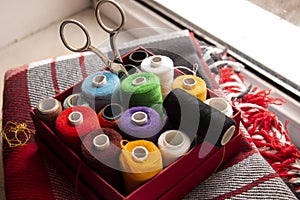 Box with multi-colored threads and scissors