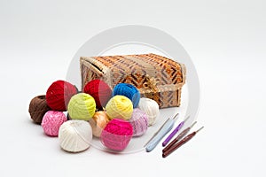 A box for needlework, colorful reels of thread and a set of hooks for home knitting. Still life on a white background