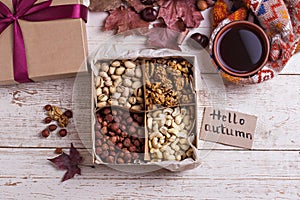 A box of nuts and dried fruits on old wooden background. hazelnut, cashew, dried daddy, dried pineapple