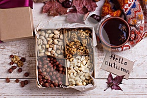 A box of nuts and dried fruits on old wooden background. hazelnut, cashew, dried daddy, dried pineapple