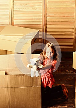 Box package and storage. Small child prepare toys for relocation. Happy childhood. Relocating family stressful for kids