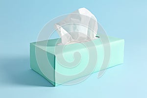 Box of paper tissues on blue background