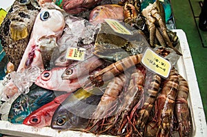 Box with raw seafood selling on market