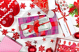 A box with a ribbon and a stack of banknotes on a white background