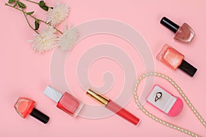 Box with ring and women cosmetics on a pink background