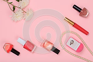 Box with ring and women cosmetics on a pink background