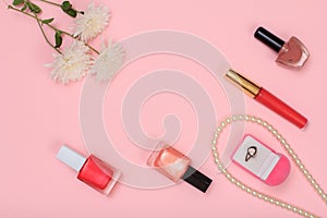 Box with ring and women cosmetics on a pink background