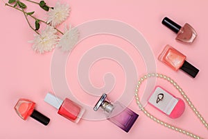 Box with ring and women cosmetics on a pink background