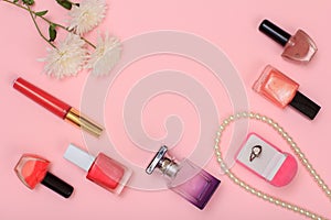 Box with ring and women cosmetics on a pink background