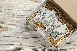 Box with scented sachets on white wooden table, top view. Space for text