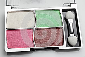 Box with set of colored eyeshadow on gray background. Blush pattern for makeup