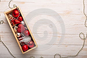 Box with silver red christmas gifts on white wooden background