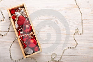 Box with silver red christmas gifts on white wooden background