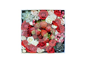 Box with small roses of different colors and berries and strawberries. isolate on white background.