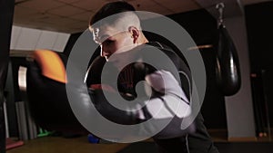 Box training - aggressive young man punching the punching bag