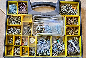 A box with variety of nails, screws, nuts, bolts and washers.