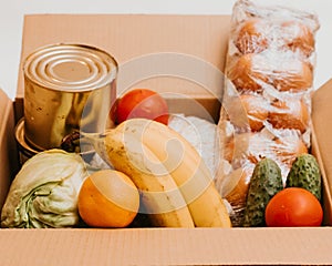 Box whith cucumbers,cereals, bananas, oranges, cabbage, tomatoes, vegetable oil,cabbage, eggs and canned goods isolated on white