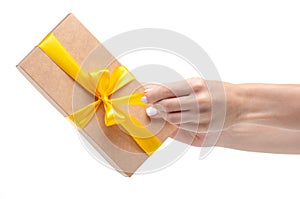 Box with yellow ribbon bow gift in hand