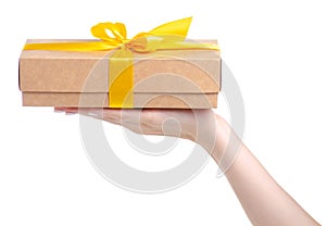 Box with yellow ribbon bow gift in hand