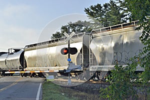 Boxcars and oil tanks at crossing