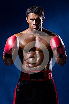 Boxer Boxing staring showing strength. Young man looking aggressive with boxing gloves.