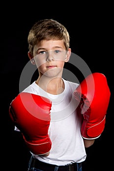 A boxer boy portrait in the defend position on the black background