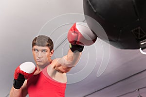 Boxer doing some training on punching bag at gym.