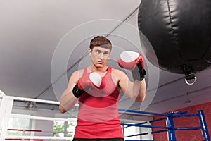 Boxer doing some training on punching bag at gym.