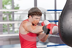 Boxer doing some training on punching bag at gym.