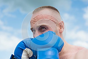 Boxer in a fight. Fist fight. Strong man strong body boxing outdoor. Man with muscular body and bare torso with boxing