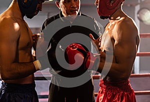 Boxer fighter with safety helmet face off with each other while referee. Impetus