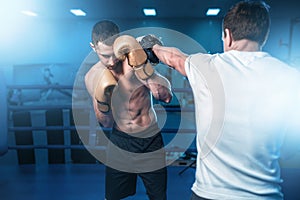 Boxer in gloves exercises with sparring partner