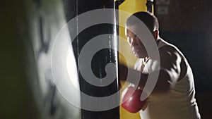 Boxer hits punching bag. The sports man beats a punching bag. The man in the gym. The trainer plays sports. Punching bag
