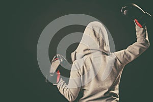 Boxer in hoodie stand backwards with arms in air.