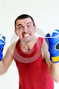 Boxer man with boxing gloves. Young handsome male athlete with boxing gloves, boxer working out, fitness Studio shot. Evil boxer