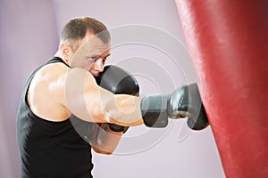 Boxer man at boxing training with heavy bag