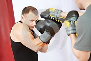 Boxer man at boxing training with punch mitts photo