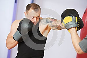 Boxer man at boxing training with punch mitts photo