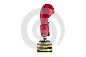 Boxer protective red glove on lifting weights wrapped with yellow measurment tape on white background photo