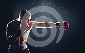 Boxer striking a blow in the rain.