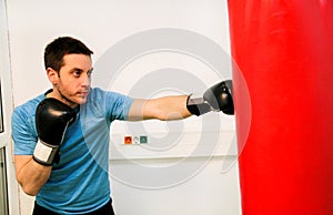 Boxer training is exercising with a punching bag at gym