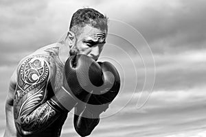 Boxer training outdoor. Male boxer training defense and attacks in boxing gloves. Boxing punch.