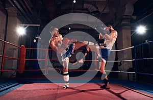 Boxers training kickboxing in the ring at the health club