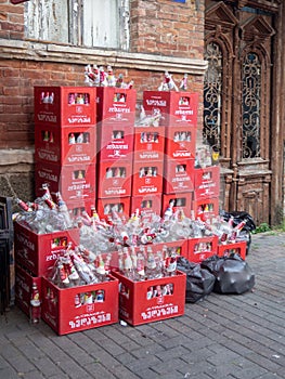 Boxes in the backyard with glass containers. Lots of empty bottles in boxes. Lemonade packaging. Many empty bottles of Zidazeni