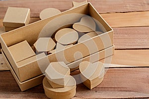 Boxes of cardboard of different sizes and shapes on a natural wooden background.