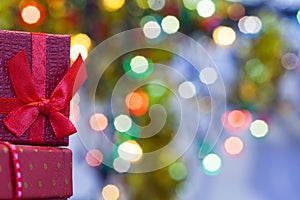 Boxes with christmas gifts with red bow and christmas bokeh light abstract holiday background