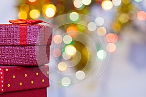 Boxes with christmas gifts with red bow and christmas bokeh light abstract holiday background.