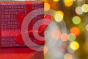 Boxes with christmas gifts with red bow and christmas bokeh light abstract holiday background